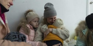 A woman whose husband was killed in the shelling cries on the floor of a corridor in a hospital in Mariupol, eastern Ukraine, March 11, 2022 (AP Photo/Mstyslav Chernov)